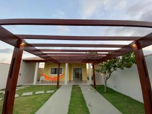 una pérgola sobre una pasarela frente a una casa en Casas Amarelas II - Prado BA en Guarani