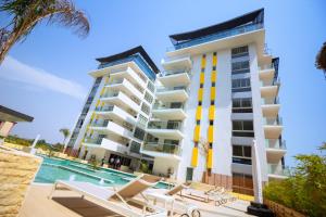 an apartment building with a swimming pool and lounge chairs at The Pavilion 1BDR Luxury Apt in Accra