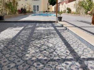 eine Kopfsteinpflasterstraße mit einem Schatten eines Gebäudes in der Unterkunft Jasmine villa in Hurghada