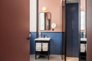 bagno con lavandino e specchio di The Editory Riverside Hotel, an Historic Hotel a Lisbona