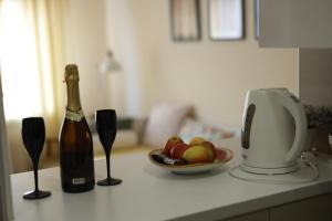 a bottle of wine and a bowl of fruit on a kitchen counter at Studio Jasna in Novi Sad