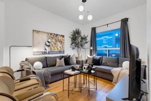 uma sala de estar com um sofá e uma televisão em Liv MTL Avenue em Montreal