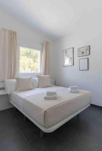 Cette chambre blanche dispose d'un grand lit et d'une fenêtre. dans l'établissement Calma Villa. Chalet de lujo, jacuzzi y piscina, à Valence 59 autres photos