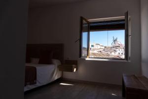 1 dormitorio con cama y ventana con vistas en Casa La Venta en Campo de Criptana