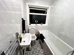baño con lavabo y aseo y ventana en Holborn en Coundon