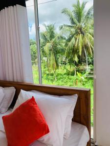 una camera da letto con finestra e un letto con cuscino rosso di Chill House safari resort a Udawalawe