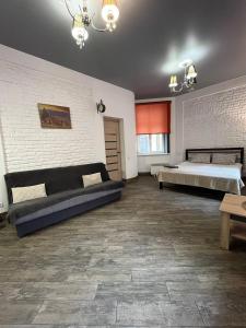 een grote kamer met 2 bedden en een bank bij Shpytalna Apartments in Lviv