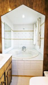 a bathroom with a tub and a sink at AA Guest - Mulhacén del Jardín Sierra Nevada in Alhendín