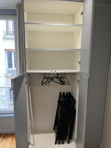 a room with a cupboard with black chairs in it at Appartement 2 personnes Paris in Paris