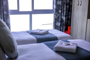 a bedroom with three beds with towels on them at Karoo Queen Houseboat, Gariepdam in Gariepdam