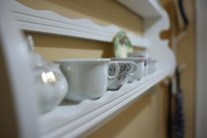 a row of cups sitting on a shelf at Studio Jasna in Novi Sad +30 photos