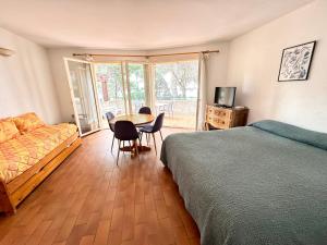 1 dormitorio con cama, mesa y sofá en Parc et Résidence le Provençal, en Hyères