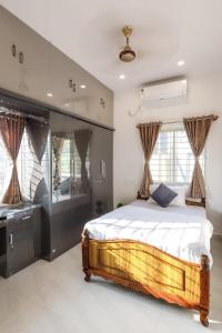 a bedroom with a bed and a sink at Whispering Willows By JadeCaps 3BHK Near Airport in Yelahanka