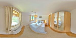 a large bedroom with a large mirror and a bed at Haus Weyerbach Apartments in Bramberg am Wildkogel