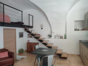 a spiral staircase in a room with a table and chairs at Charme et authenticité dans une ferme. in Lourmarin