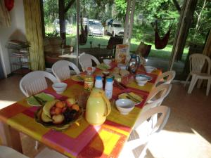 a table with a bowl of fruit and a bottle of juice at Les Hébergements Nature et Bien-être in Soustons