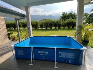 - une piscine bleue sur une terrasse avec vue sur un champ dans l'établissement Sunny Lake House, à Behrang Hulu