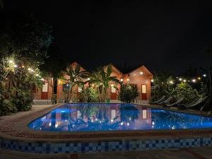 Una gran piscina frente a una casa por la noche. en Nhà Điệp Bungalow Ninh Binh, en Ninh Binh