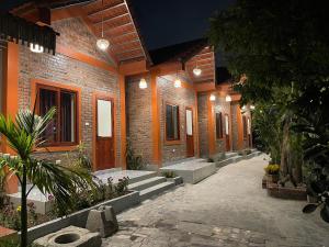einen Innenhof eines Backsteingebäudes mit Pflanzen und Lichtern in der Unterkunft Nhà Điệp Bungalow Ninh Binh in Ninh Bình