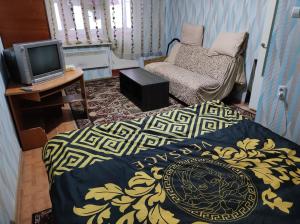 a room with two beds and a tv and a chair at Hotels in Orhei