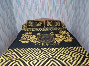 a bed with a black and gold blanket and pillows at Hotels in Orhei