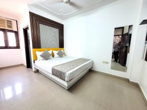 a bedroom with a bed in a white room at HOTEL ANCHAL DX in New Delhi