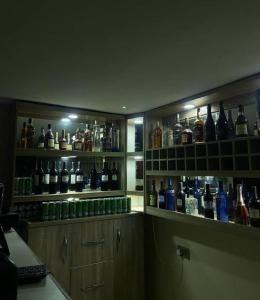 una stanza con molte bottiglie di alcol sugli scaffali di Hexagon Hotel ad Asi