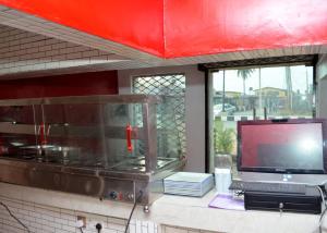a kitchen with a counter with a tv and a tv at Hexagon Hotel in Asi