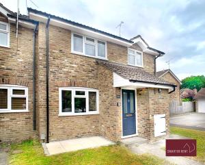 a brick house with a blue door at Farnborough - Newly Refurbished 2 Bedroom Home in Blackwater
