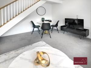 Farnborough - Newly Refurbished 2 Bedroom Home في Blackwater: غرفة معيشة بها درج وطاولة وكراسي