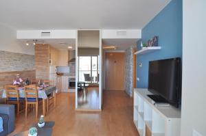 een woonkamer en eetkamer met een grote televisie bij RNET - 402 - Porto Marina - Roses Costa Brava in Roses