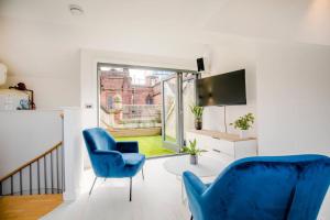 a living room with two blue chairs and a table at Central Townhouse With Roof Terrace in Manchester