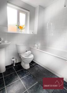 La salle de bains est pourvue de toilettes, d'une baignoire et d'un lavabo. dans l'établissement Finchampstead, 1 Bedroom House with garden, à Finchampstead