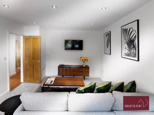 uma sala de estar com um sofá e uma mesa em Sunninghill Village - 2 Bed - Parking and garden em Ascot