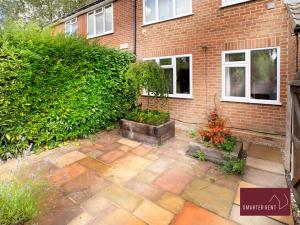 einen Garten vor einem Backsteingebäude in der Unterkunft Sunninghill Village - 2 Bed - Parking and garden in Ascot