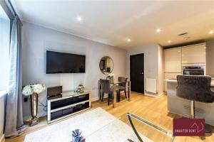 a living room with a television and a dining room at Wooburn Green - Modern One Bedroom Apartment in Bourne End