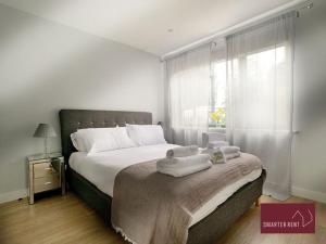 1 dormitorio con 1 cama grande y toallas. en Wooburn Green - Modern One Bedroom Apartment en Bourne End