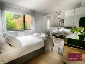 Bourne EndにあるWooburn Green - Modern One Bedroom Apartmentのベッドルーム(大型ベッド1台付)、リビングルームが備わります。