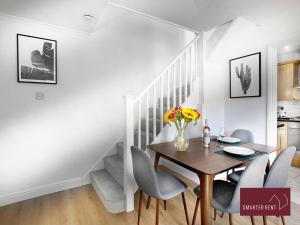 a dining room with a table and chairs and a staircase at Bisley - 2 Bedroom House - Front Garden and Parking in Bisley