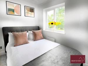 a bedroom with a bed with a vase of flowers at Bisley - 2 Bedroom House - Front Garden and Parking in Bisley