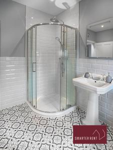 a bathroom with a shower and a sink at Thames Ditton - Luxury 4 Bedroom House - Garden and Parking in Thames Ditton