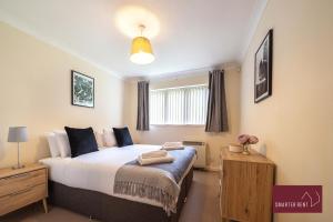ein Schlafzimmer mit einem großen Bett und einem Fenster in der Unterkunft Maidenhead - 2 Bed & parking in Maidenhead
