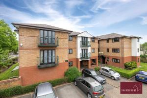 a large brick building with cars parked in a parking lot at Maidenhead - 2 Bed & parking in Maidenhead