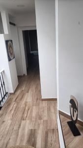 a room with a wooden floor and a hallway with a chair at APARTAMENTOS LUZ DE LA BAHÍA SUR CADIZ San Fernando in San Fernando