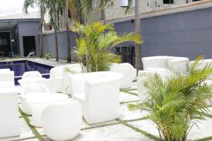a row of white chairs next to a pool at Blue Apple Hotel in Lekki