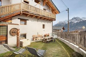 a patio with chairs and a table and a building at Il Capriolo Aosta in Aosta