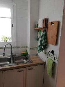 une cuisine avec un évier et une fenêtre dans l'établissement IDEALLY located on BEACH, à Port Saplaya