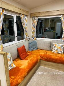 un canapé dans une pièce avec des oreillers dessus dans l'établissement 2 Bed Chalet - Sleeps 5 - Garden - Parking - Wifi, à Prestatyn