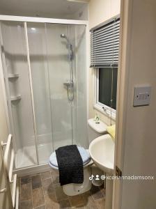 une salle de bains avec douche, toilettes et lavabo dans l'établissement 2 Bed Chalet - Sleeps 5 - Garden - Parking - Wifi, à Prestatyn 9 autres photos
