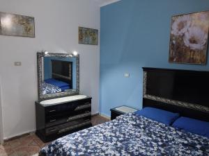 ein Schlafzimmer mit einem Bett und einem Spiegel an der Wand in der Unterkunft Jasmine villa in Hurghada + 7 Fotos